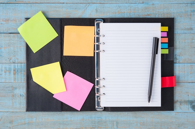 Free photo notebook  and pen on blue wood table