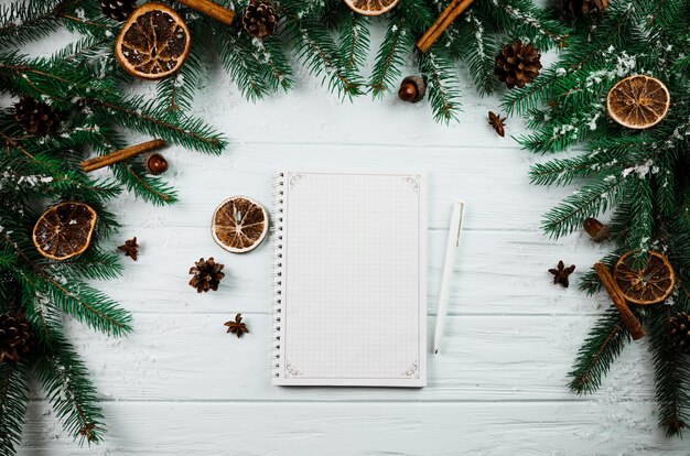 Notebook and pen between fir twigs