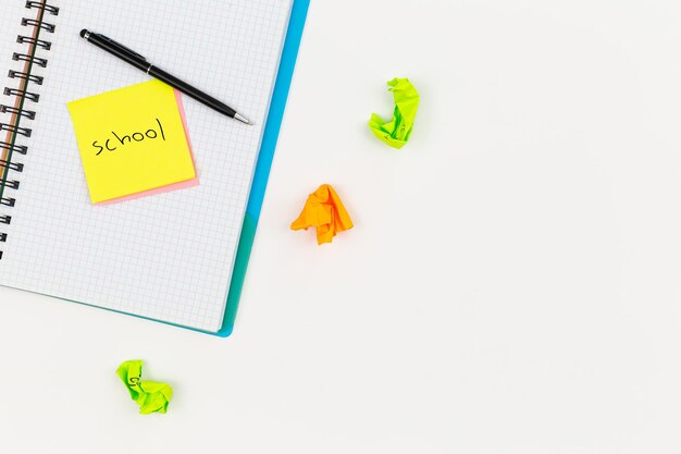 Free photo notebook pen and paper colored reminders on a white background