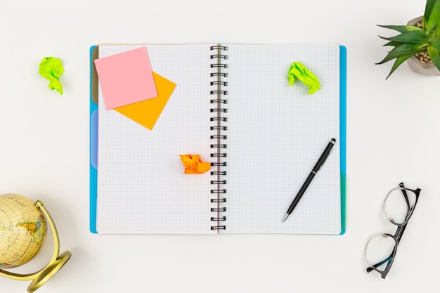 Notebook pen and paper reminders on a white background