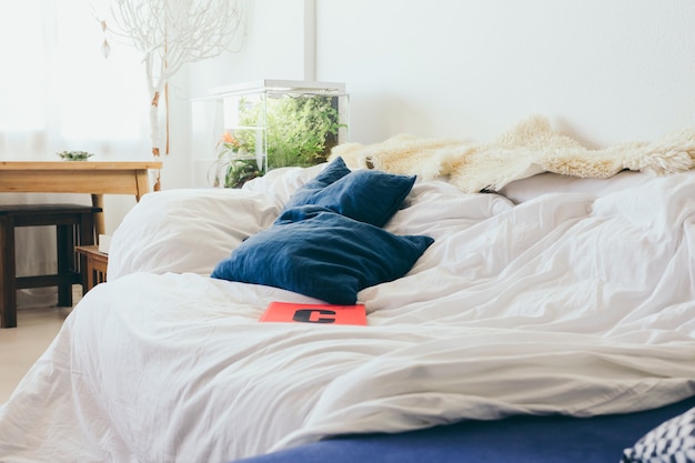Ноутбук и подушки, лежащие на кровати