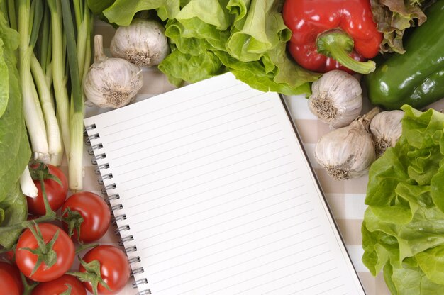 Notebook surrounded by vegetables