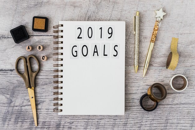 Notebook with 2019 goals inscription near set of stationery 