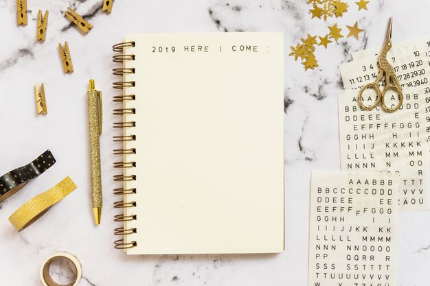 Notebook with 2019 here I come inscription near set of stationery