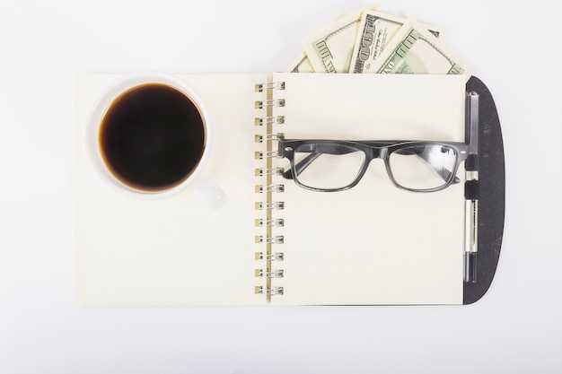 Notebook with coffee and glasses on desk