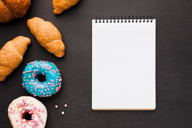 Notebook with doughnuts and croissant