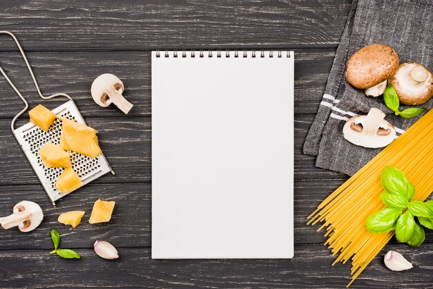 Notebook with ingredients for spaghetti with mushrooms