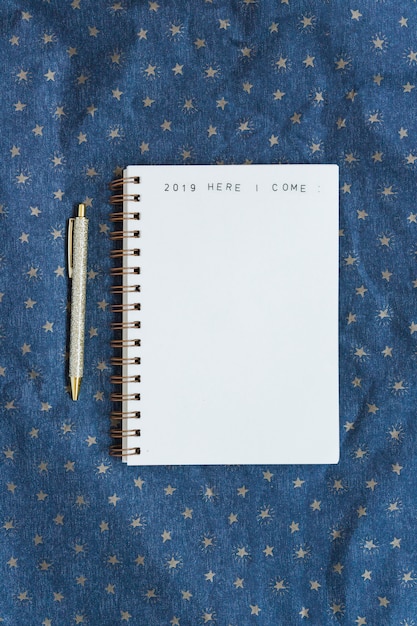 Free photo notebook with inscription near pen