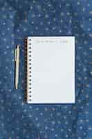 Free photo notebook with inscription near pen