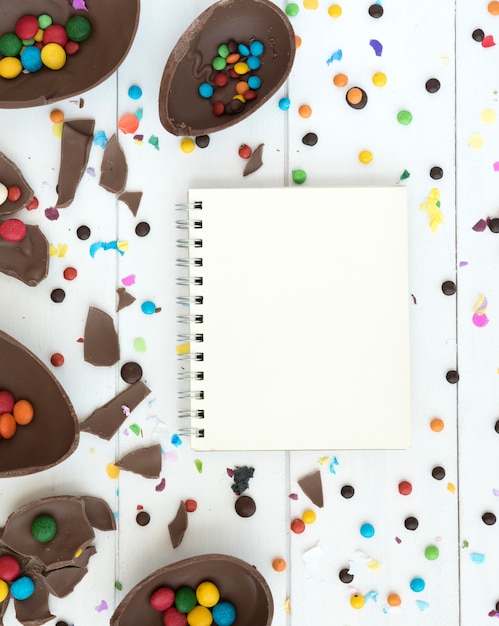 Notebook with open chocolate Easter eggs and candies