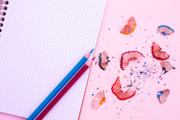 Free photo notebook with pencil and sharpness on pink background