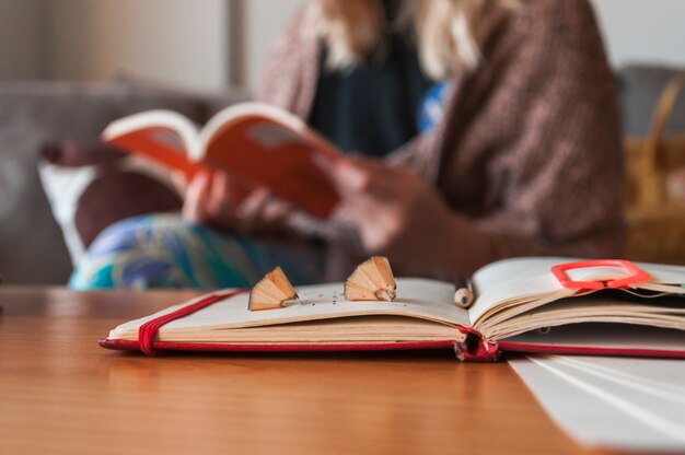 Notebook with pencil and shavings near woman