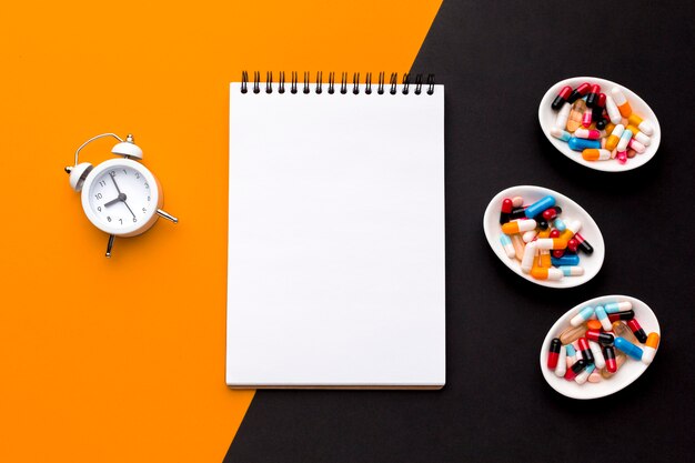 Notebook with pills and clock