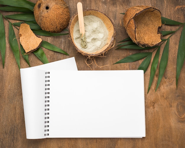 Notebook with powder in coconut shell and leaves