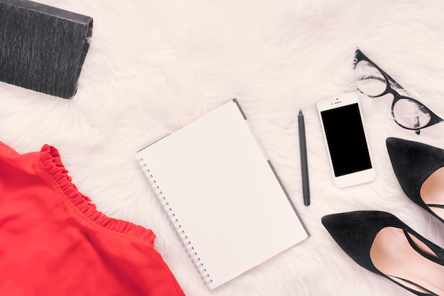 Notebook with smartphone and skirt on blanket 