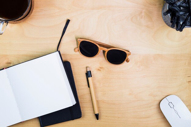 Notebook with sunglasses on table