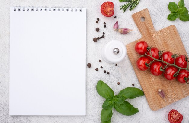 Notebook with tomatoes on wooden bottom on table