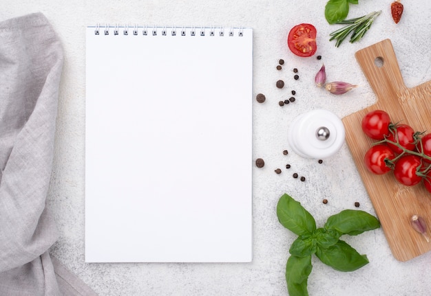 Free photo notebook with tomatoes on wooden bottom