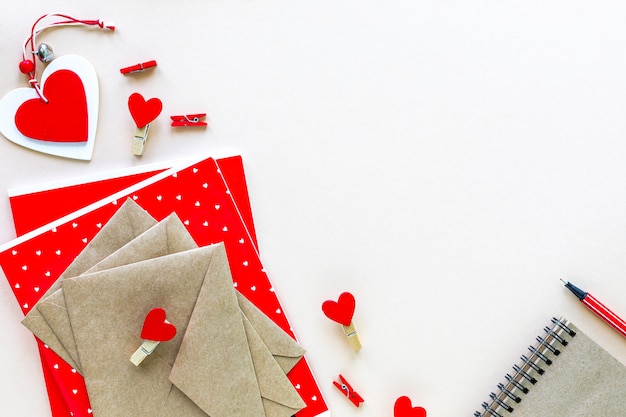 Notebooks and envelopes for school or office in red on a white table with copy space.