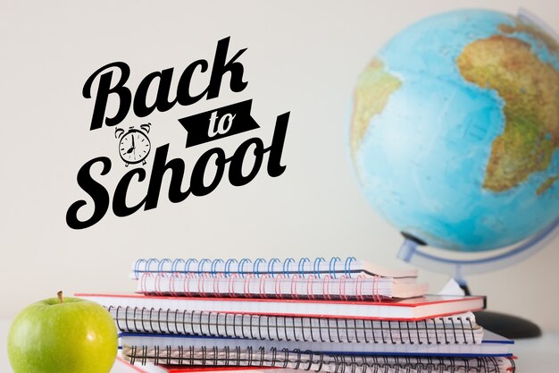 Notebooks and globe with the phrase back to school