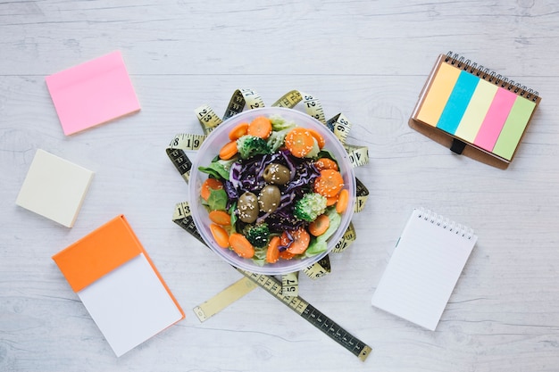 Free photo notebooks and measuring tape around salad