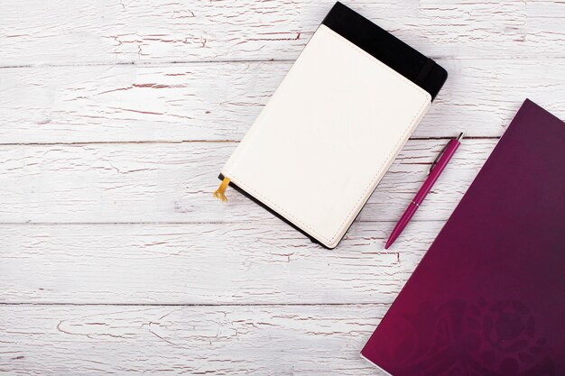 The notebooks and pen stand on the table