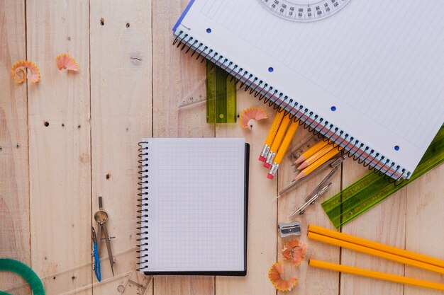 Notebooks with school supplies on wooden