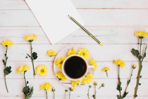 Foto gratuita blocco note e caffè con fiori gialli