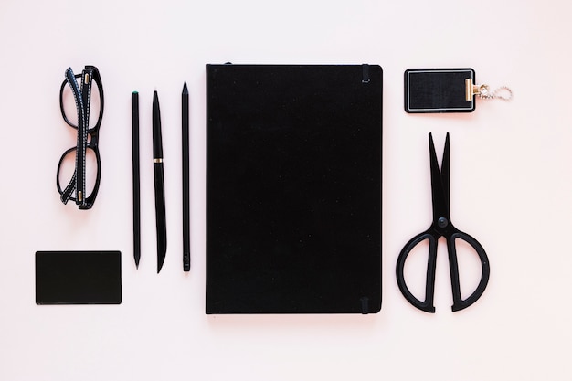 Notepad near stationery on pink table