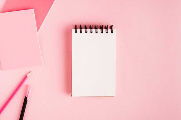 Notepad and office supplies on colored surface