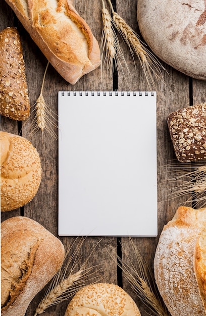 Free photo notepad surrounded by wheat and bread