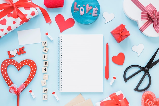 Foto gratuita blocco note tra titolo di san valentino e decorazioni diverse