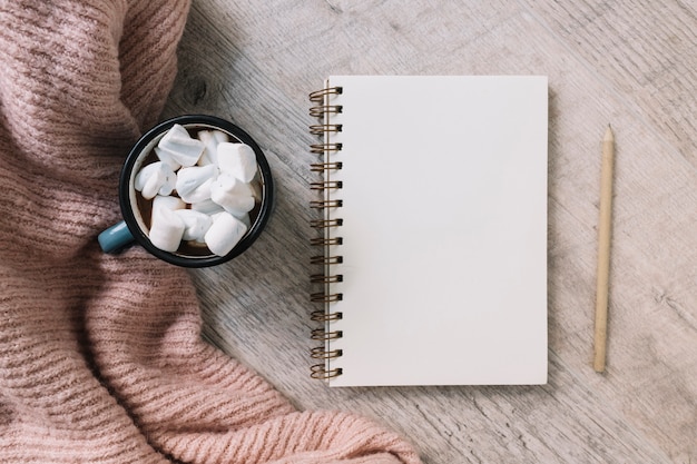 Notepad with cup of marshmallows