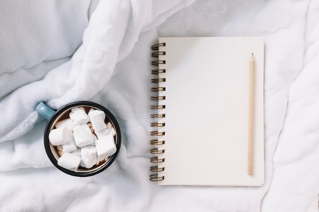 Notepad with cup of soft marshmallows