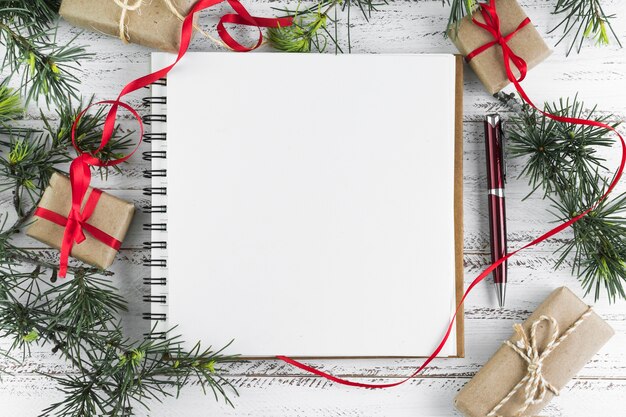 Notepad with fir tree branches on table