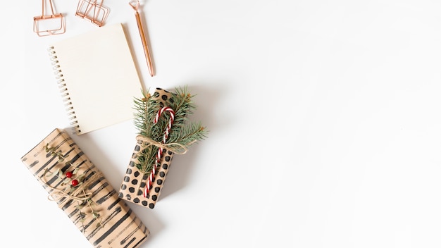 Notepad with gift boxes on table 