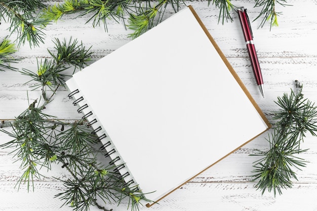 Notepad with green fir tree branches 