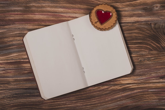 Free photo notepad with a heart on a wooden table