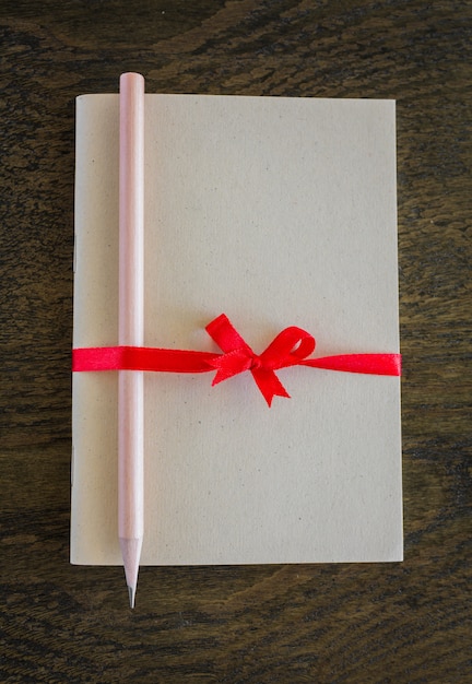 Notepad with a pencil tied with a red bow