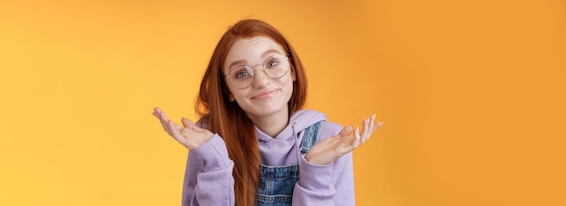 Free photo nothing much attractive silly unsure carefree redhead unbothered cute female wearing geek glasses sm