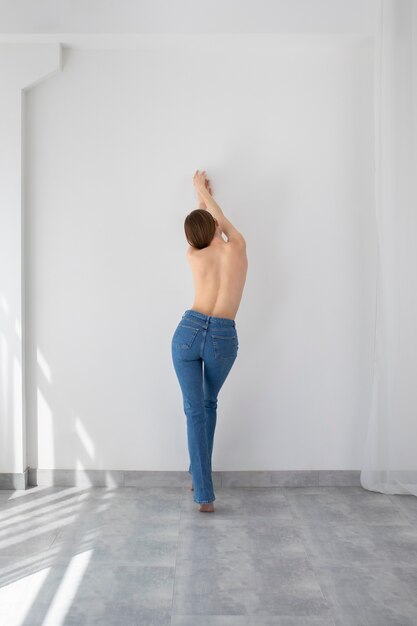Nude woman posing in jeans full shot