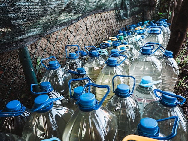 Number of plastic bottles full of water in front of the wall in the garden