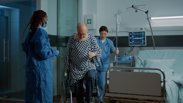 Free photo nurse and african american doctor helping seat sick patient