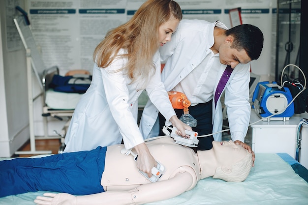 Nurse conducts resuscitation. Doctor helps woman to perform the operation. 