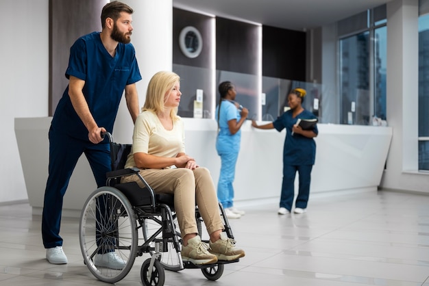 Nurse helping patient in wheelchair side view