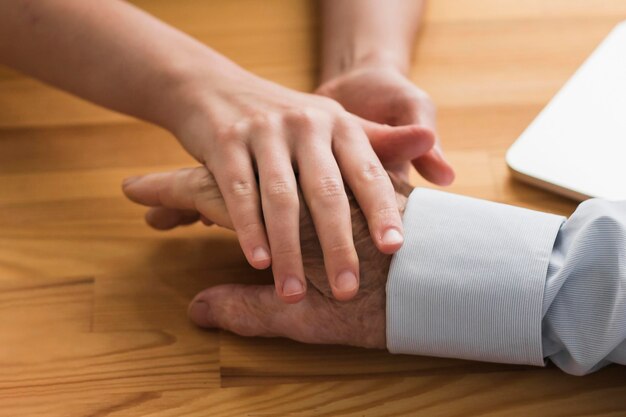 Nurse holding old man's hand in a nursing home