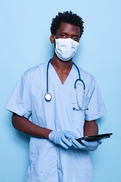 Free photo nurse holding tablet while looking at camera over isolated background