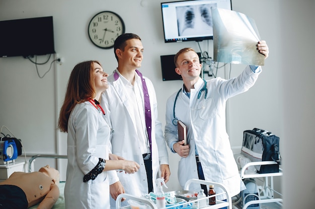 Nurse listens to the doctor.Students in hospital gowns. Men and woman standing in a hospital ward.