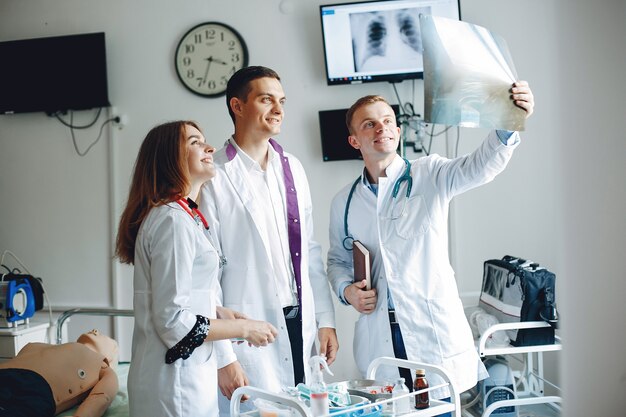 Nurse listens to the doctor.Students in hospital gowns. Men and woman standing in a hospital ward.