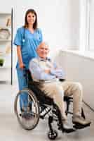 Foto gratuita infermiere e uomo anziano in posa mentre guardando la telecamera